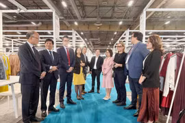 越南驻法国大使丁全胜与参加展览的越南企业代表交流。图自越通社