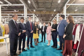 越南驻法国大使丁全胜与参加展览的越南企业代表交流。图自越通社