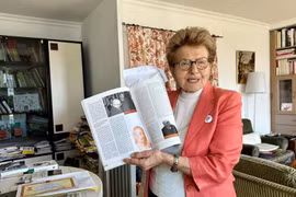 海伦·吕克介绍她珍藏的关于胡志明主席的资料。图自越通社