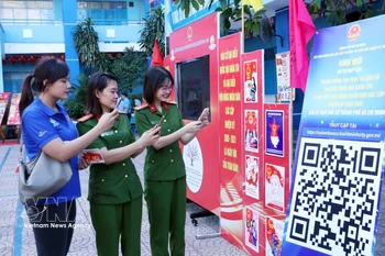 胡志明市年轻选民通过扫描二维码（QR码）参加《选举法》在线知识竞赛。图自越通社