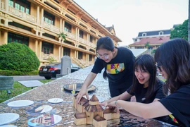 年轻人们在国家历史博物馆与展品进行互动。图自越通社