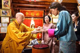 镇国寺住持释清雅和尚向越南国家主席梁强的夫人阮氏明月与不丹王后吉增·佩玛·旺楚克赠送菩提叶。图自越通社