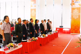 收看越共十四大开幕式的电视直播的代表们。图自越通社