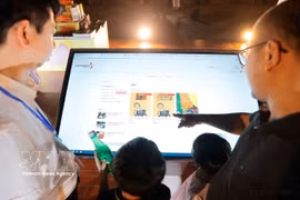 参观者体验电子图书。图自越通社