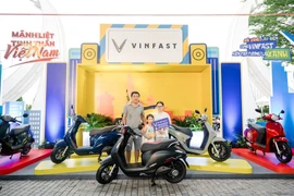 汽油摩托车换成 VinFast Evo200电动车活动的第一位客户。图自越通社