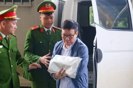 合并前的永福省人民委员会原主席黎维成被押解至法庭出庭受审。图自越通社