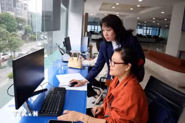 河内市公共行政服务中心工作人员协助民众办理行政手续。图自越通社