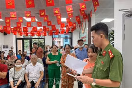 河内市栋多坊公安力量引导并解答市民疑问，确保礼金发放工作快速、高效地进行。图自越通社
