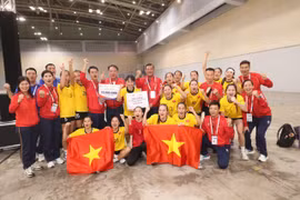 越南女子手球队球员和教练组庆祝胜利。图自越通社