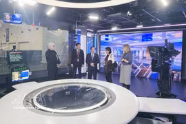 越共中央政治局委员、中央书记处书记、中央宣教部部长郑文决和代表们参观澳大利亚广播公司新闻制作基础设施。图自越通社