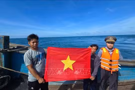 职能力量向渔民赠送国旗。图自越通社