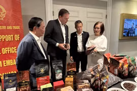 越南驻加拿大商务参赞陈秋琼向加拿大咖啡协会主席罗伯特·卡特介绍越南咖啡。图自越通社