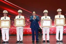 范明政总理向在工作中取得优异成绩的集体和个人授予“人民武装力量英雄”称号和一级军功勋章。图自越通社