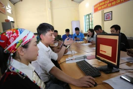 引导少数民族同胞办理在线公共行政手续。图自越通社