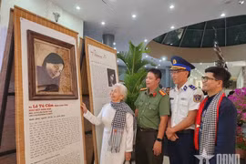 昆岛前政治犯黎秀锦观看年轻时期的肖像画。图自qdnd.vn