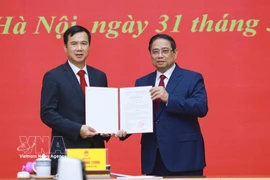 范明政总理向河内国家大学新任校长裴世维颁发任命决定。图自越通社