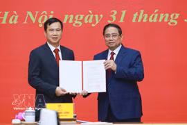 范明政总理向河内国家大学新任校长裴世维颁发任命决定。图自越通社