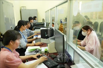 胡志明市泰美乡干部、公务员为群众办理行政手续。图自越通社