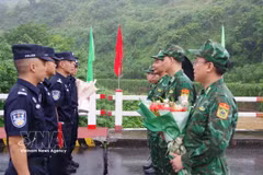 双方巡逻指挥长代表在越中边境友谊桥分界线上互相献花。图自越通社