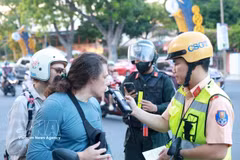 庆和省公安厅交通警察对外国游客进行酒精浓度检测。图自越通社