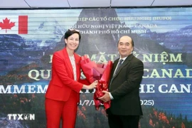 胡志明市友好组织联合会副主席兼秘书长胡春林向加拿大驻胡志明市总领事安妮·杜贝送花祝贺。图自越通社