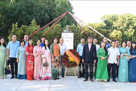 旅居哈瓦那越南人代表在胡志明主席塑像献花。图自越通社