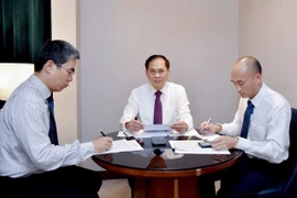 越南政府副总理兼外交部长裴青山（左二）与韩国外长赵显通电话。图自越通社