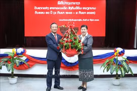 老挝人民革命党中央宣训部副部长薇拉翁·潘塔冯向越南驻老挝大使阮明心送花。图自越通社
