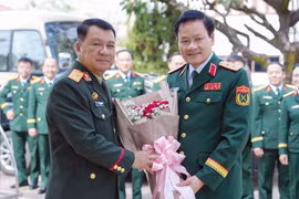老挝人民军总政治局宣训局局长科苏万·潘菲拉翁少将迎接越南人民军总政治局宣训局局长阮文德中将（右）。图自越通社