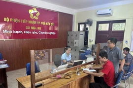 居民在乂安省峨眉乡公共行政服务中心办理行政手续。图自越通社