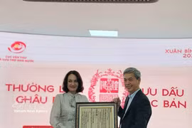 越南国家文书与档案局局长邓青松向俄罗斯驻越大使夫人埃琳娜·贝兹德特科赠送一幅越南国号的木刻版画。图自越通社