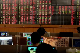 投资者在电子显示屏上关注股票波动。图自路透社