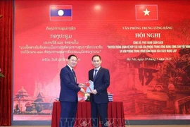 越共中央书记处书记、中央办公厅主任黎淮忠向老挝人民革命党中央书记处书记、中央办公厅主任通沙立·蒙诺梅赠送《越共中央办公厅和老挝人民革命党中央办公厅合作关系传统》一书。图自越通社