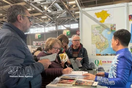 游客在3月12日至15日于巴黎举行的世界旅游展览会上了解越南旅游项目。图自越通社