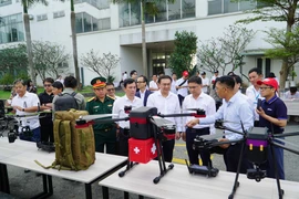 各位代表参观无人机。图自越通社