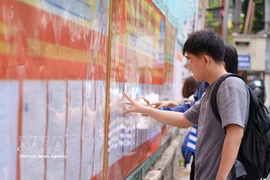 岘港技术教育大学的大学生们正在研究学校张贴的候选人名单。图自越通社