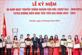 越共中央总书记苏林和文化体育旅游部部长阮文雄向先进典型颁发奖状和鲜花。 图自越通社