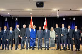 越南内务部副部长武战胜与越南驻奥地利大使武黎泰黄和两国代表合影。图自越通社