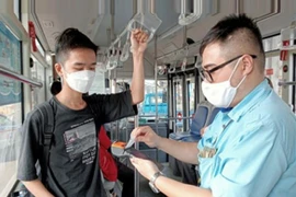 河内交通运输公司的员工使用手持设备销售和管理公交车票。图自hanoimoi.com