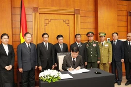 老挝人民革命党中央总书记、国家主席通伦·西苏里在吊唁簿上留言。图自越通社