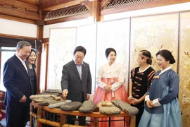 苏林总书记夫妇向韩国总统李在明夫妇介绍越南石琴艺术。图自越通社