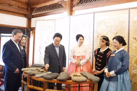 苏林总书记夫妇向韩国总统李在明夫妇介绍越南石琴艺术。图自越通社