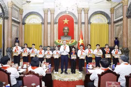 越共中央总书记、国家主席苏林向胡志明少年先锋队优秀队员赠送《胡伯伯与儿童》图片。图自越通社