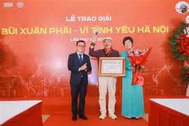越南记者协会主席、《人民报》总编辑黎国明与越通社社长武越庄为陈进颁授“热爱河内”大奖。图自越通社