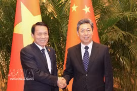 越共中央政治局委员、公安部长梁三光大将（左）与中共中央政治局委员、中央政法委员会书记陈文清。图自越通社