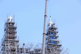 西贡圣母大教堂两座重达800多公斤的镀金十字架已成功安装在约60米高处的锌制塔尖上。图自越通社