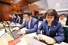 越通社记者在越共十四大新闻中心进行报道工作。图自越通社