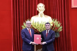 越共中央政治局委员、中央书记处书记、中央组织部部长黎明兴向范大洋同志颁发任命决定。图自越通社