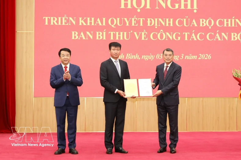 越共中央政治局委员、中央书记处书记、中央组织部部长黎明兴向陈辉俊同志颁发决定。图自越通社