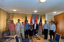 越南国际象棋队棋手与越南驻瑞士大使馆干部合影。图片来源：越通社发